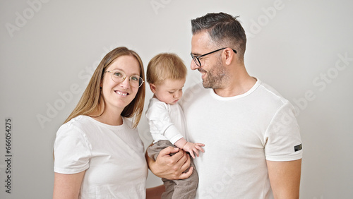 Family of mother, father and baby smiling together over isolated white background