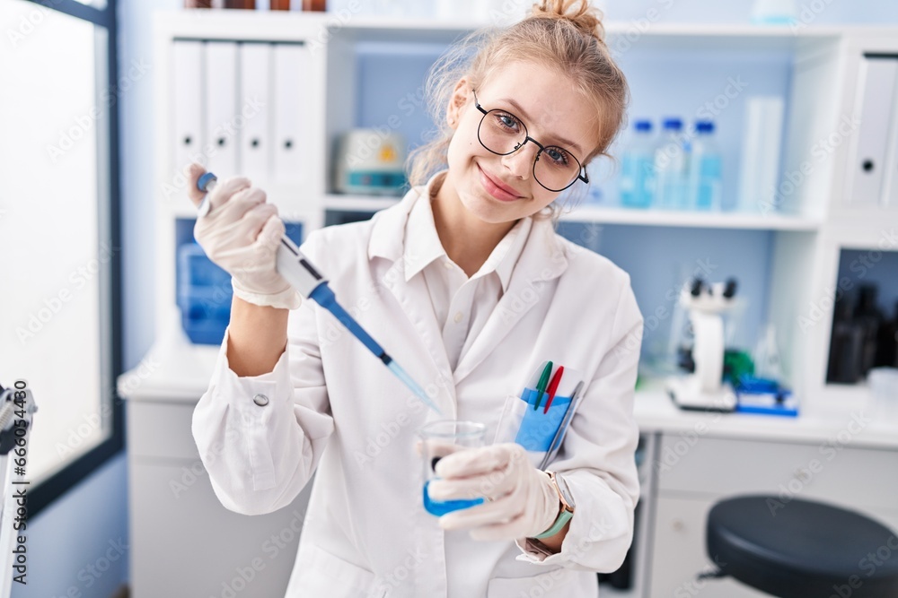 Young blonde woman scientist smiling confident pouring liquid on test tube at laboratory Young blonde woman scientist smiling confident pouring liquid on test tube at laboratory