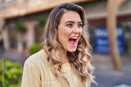 Young woman standing with surprise expression at street