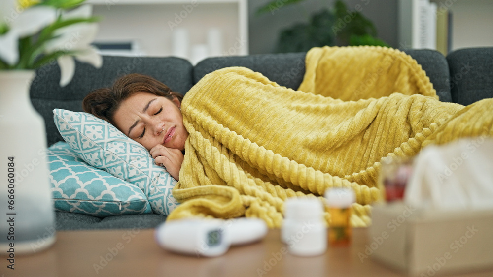 Εκτύπωση καμβά Young beautiful hispanic woman lying on the sofa sick with tissues and pills on