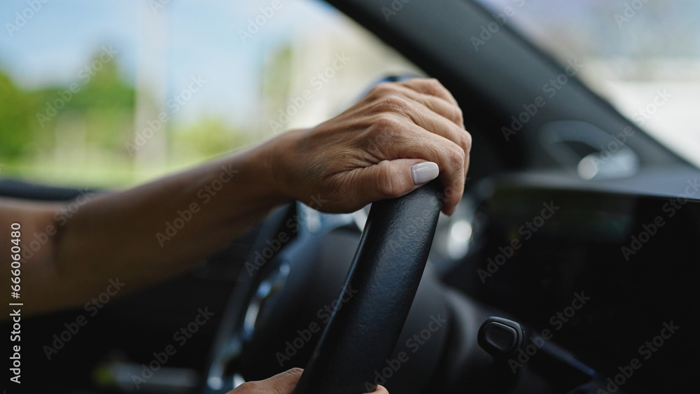 Middle age hispanic woman driving a car on the road