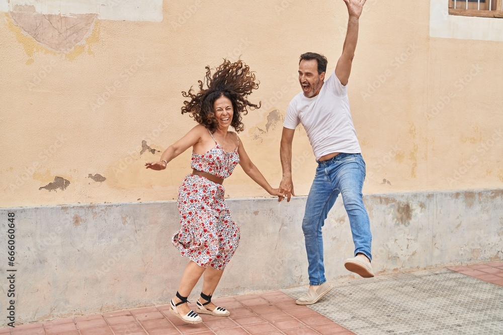 Man and woman couple smiling confident dancing at street