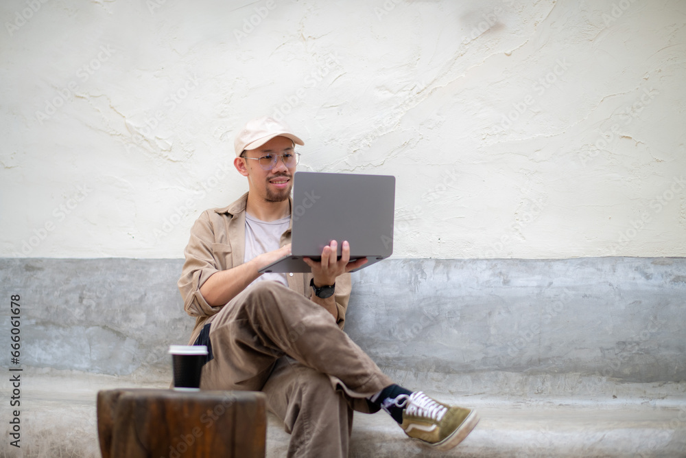 Freelance man wearing a cap having a relaxed video call in an online meeting using a laptop. Freelance man wearing a cap having a relaxed video call in an online meeting using a laptop.