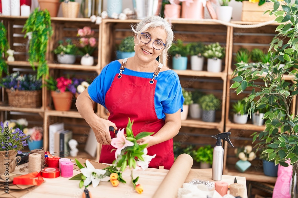 Middle age grey-haired woman florist make bouquet of flowers at florist Middle age grey-haired woman florist make bouquet of flowers at florist