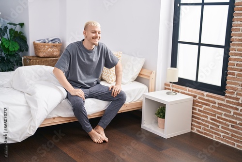 Young caucasian man smiling confident sitting on bed at bedroom © Krakenimages.com