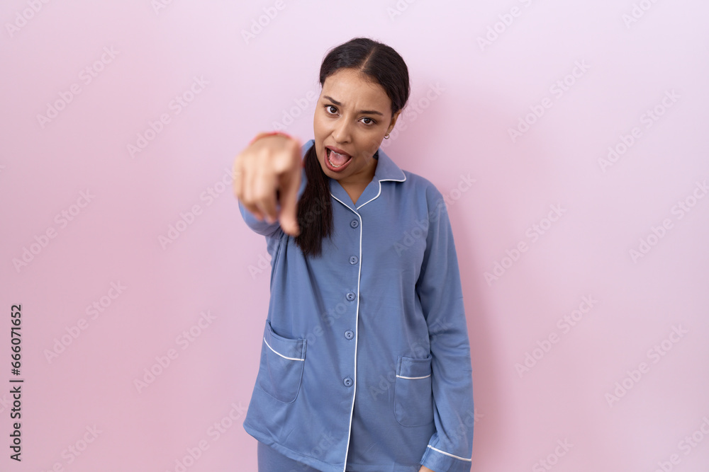 Young arab woman wearing blue pajama pointing displeased and frustrated to the camera, angry and furious with you Young arab woman wearing blue pajama pointing displeased and frustrated to the camera, angry and furious with you