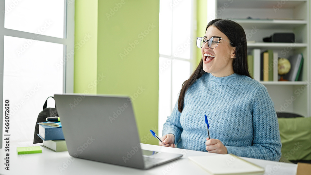 Young hispanic woman student using pen as a drummer at library university Young hispanic woman student using pen as a drummer at library university