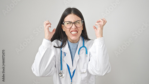 Young hispanic woman doctor angry and stressed over isolated white background