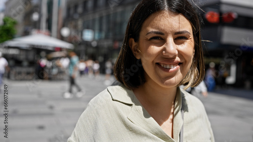 Canvas Print Young beautiful hispanic woman smiling confident standing in the streets of Vien