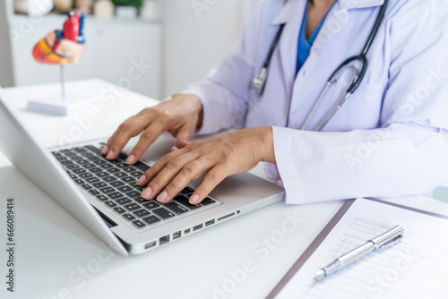 Doctor consult patient on laptop with anatomical model of human