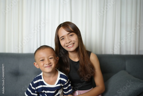 Mother and son smiling happily inside the house