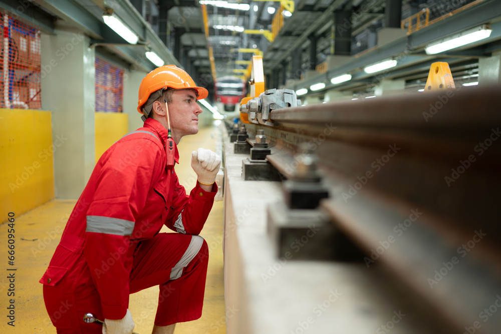 Obraz premium After the electric train is parked in the electric train repair shop, an electric train technician with tools inspect the railway and electric trains in accordance with the inspection round