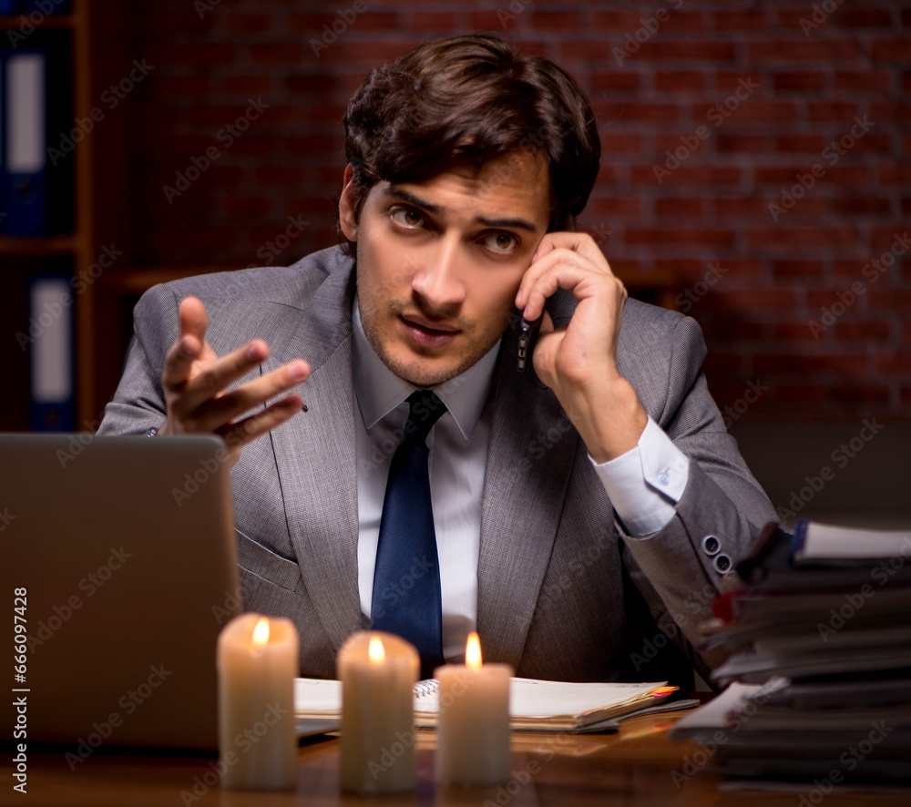 Businessman working late in office with candle light Businessman working late in office with candle light