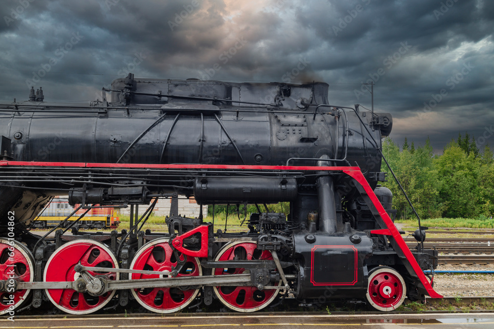 Naklejka premium An old steam locomotive of the early 20th century on the railway track.