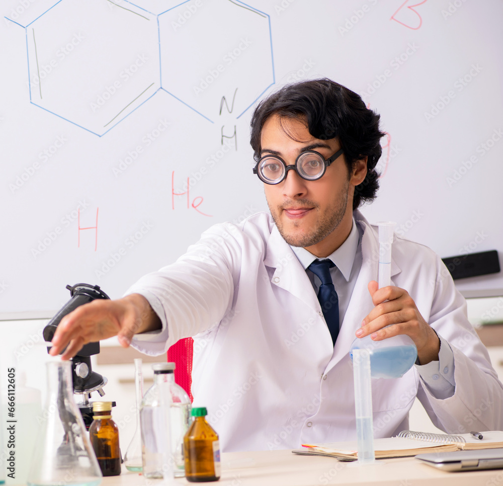 Young funny chemist in front of white board Young funny chemist in front of white board