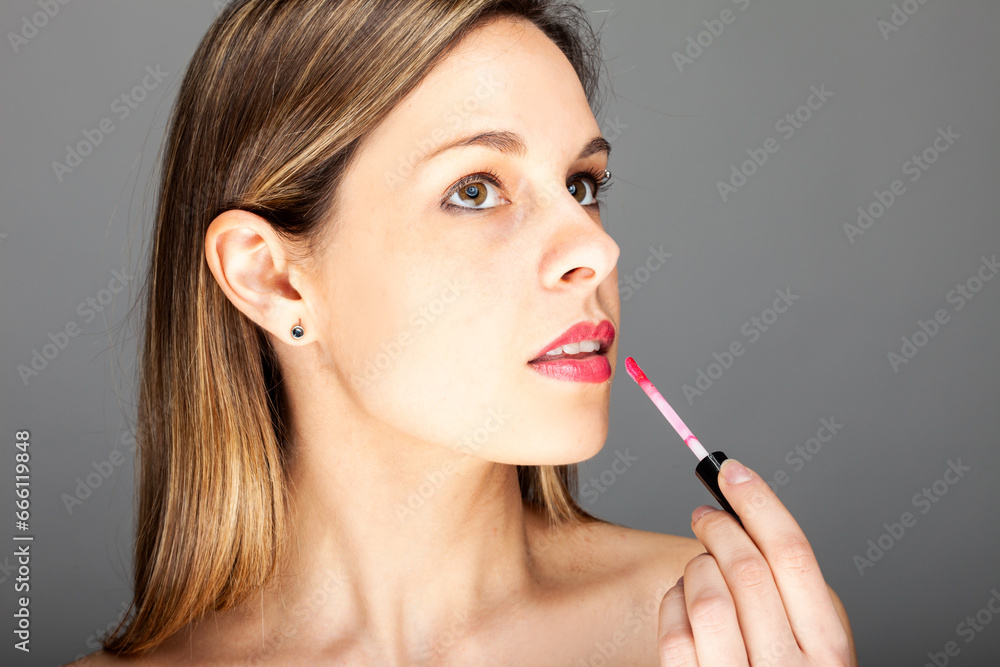 Beautiful charming woman applying lipstick Beautiful charming woman applying lipstick