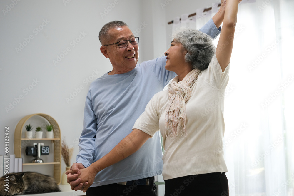 Obraz premium Selective focus of senior couple holding hands while dancing in living room