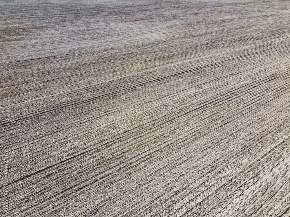 Plowed soil, aerial view, landscape. Lots of traces from vehicles on the ground.