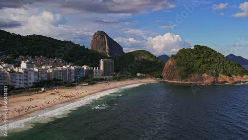 Drone footage of Copacabana Beach in Rio de Janeiro Brazil. The video starts above the sea and we do a slowly dolly movement to go to the corner of the beach with the pao de a�ucar behind photo