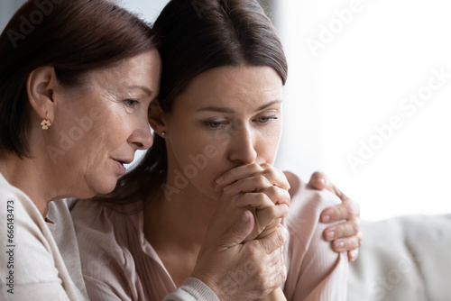 Obraz na płótnie Loving worried mature mom comforting sad adult daughter faces close up, understa