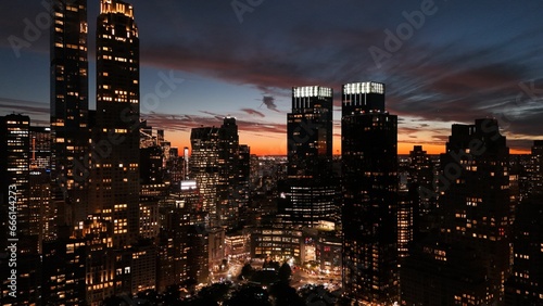 a city skyline is lit up by buildings at sunset time