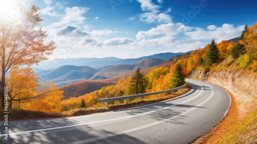 A winding mountain road with vibrant fall foliage and a clear, sunny day