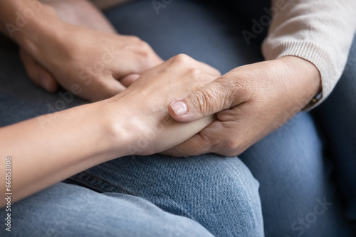 Close up women holding hands seated indoors, older mother supporting adult child showing love and protection. Empathy, making peace, heart-to-heart talk of parent and daughter, tender moment concept © fizkes