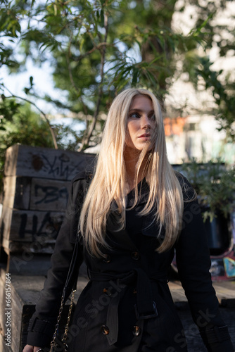 Blond wonderful woman with black dress in autum dance in the wind