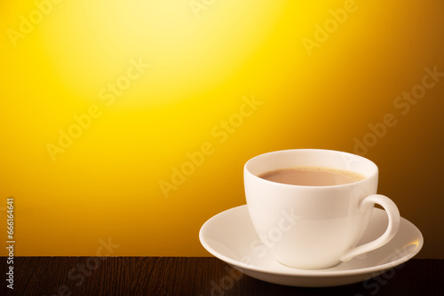 Cup of tea on yellow background with text space