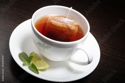 Cup of lemon tea with tea bag at wooden table