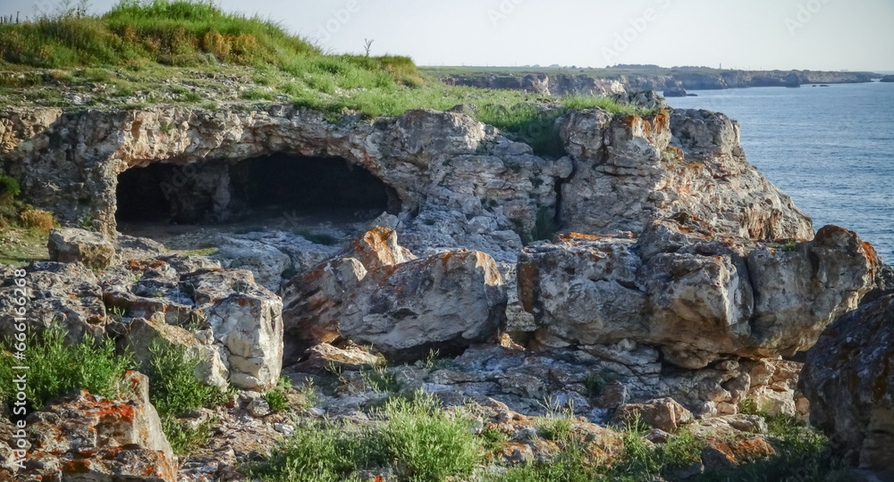 Cave in the rocks on the stone shore of the Black Sea near Tyulenovo village
