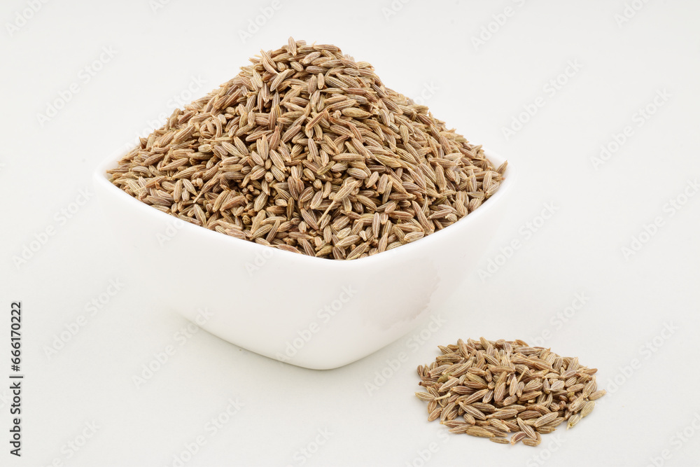 Cumin seeds in bowl on white background Cumin seeds in bowl on white background