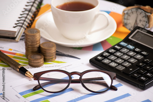 Eyeglasses at office table with calculator and cup of tea