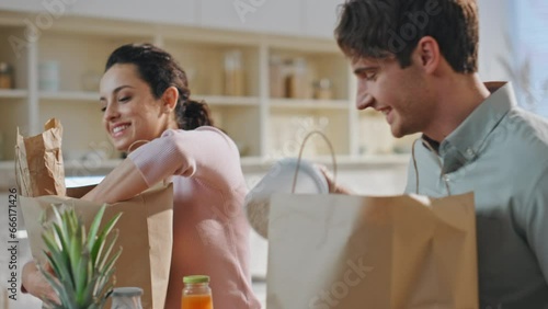 Couple unpacking delivered products at kitchen together closeup. Online services photo
