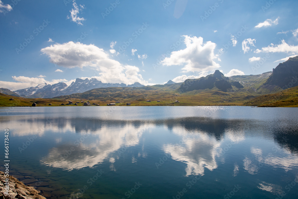 Clouds are reflected in the clear water of a mountain lake. Melchsee-Frutt near Lucerne, Switzerland in the Swiss Alps. Idylic Lake Landscape in summer.