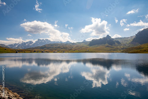 Clouds are reflected in the clear water of a mountain lake. Melchsee-Frutt near Lucerne, Switzerland in the Swiss Alps. Idylic Lake Landscape in summer.