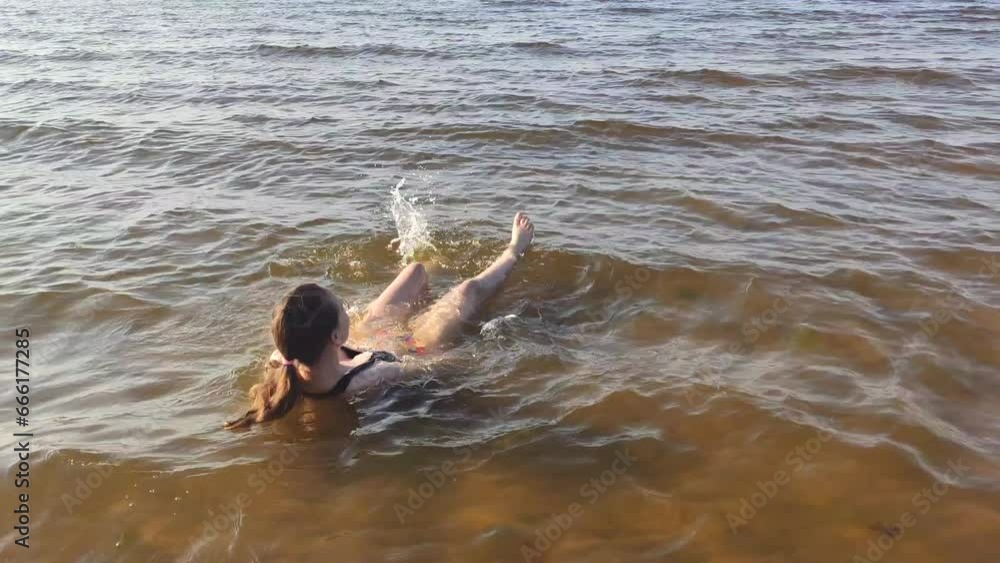 The child enjoys bathing in the sea water on the coast. The child enjoys bathing in the sea water on the coast.
