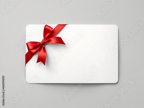 Blank white gift card with red bow on gray background.