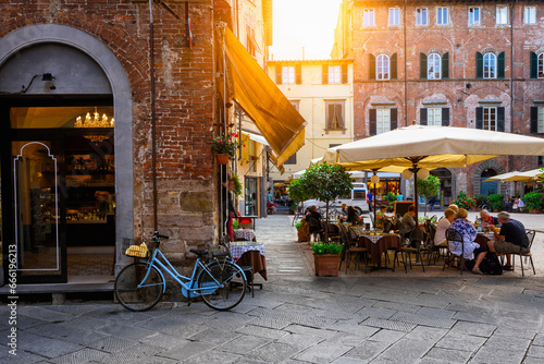 Fototapeta Naklejka Na Ścianę i Meble -  Old cozy street with tables of restaurant in Lucca, Italy