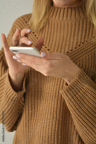 Chic authentic young businesswoman, having a friendly conversation over her smartphone during downtime from work.