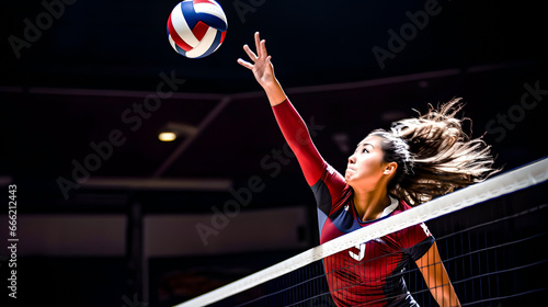 An Asian volleyball player passing the ball over the net photo