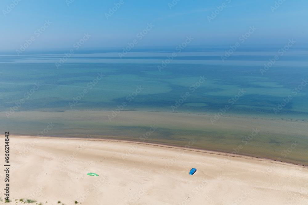 Aerial landscape of the summer beach with lonely blue fishing boat resting on the sand. Baltic sea, Lithuania