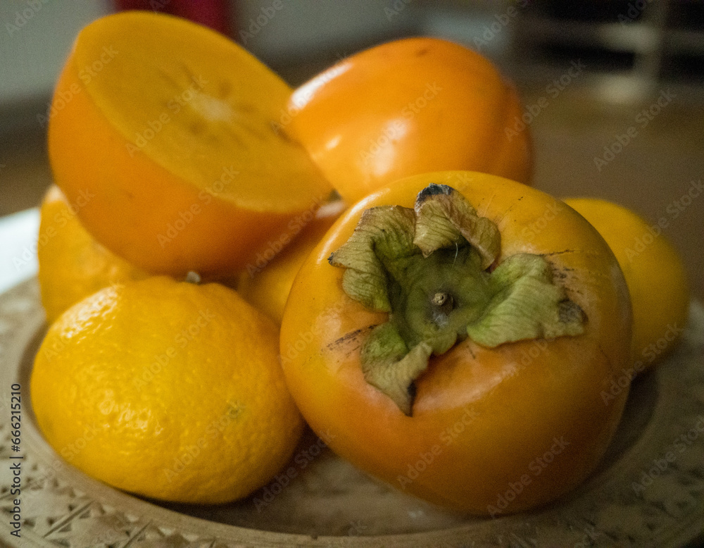 Sweet Persimmon, one of the delicious fruit types, with tangerines lying