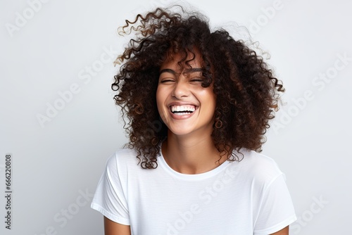 A cheerful and happy young African American woman with curly hair, exuding positivity and enjoying life outdoors.