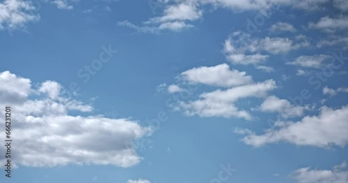 Timelapse, white clouds forming, moving on blue sky background. Light movement of weightless clouds across blue sky surface. 4k time lapse static video. Light cloud in summer nature. Cloudy weather