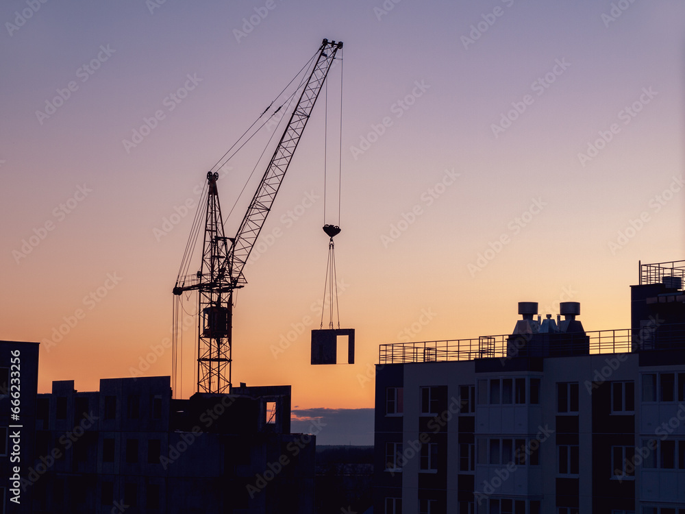 Lifting high-rise crane during work construction of high-rise buildings of the desired residential building concept construction Lifting high-rise crane during work construction of high-rise buildings of the desired residential building concept construction