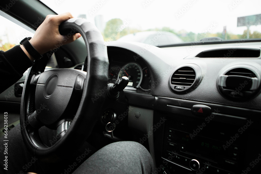 The driver keeps his hand on the steering wheel. Vehicle interior