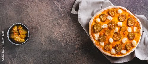 Spicy pizza with cheese and pickles on a wooden board on the table top view web banner