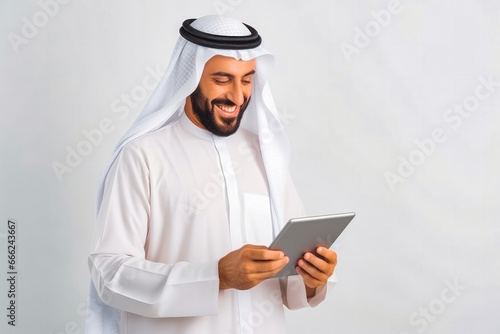 Happy Arabic man using tablet on white wall in smart home. Modern home innovation and technology. Using a mobile tablet to control smart home. photo