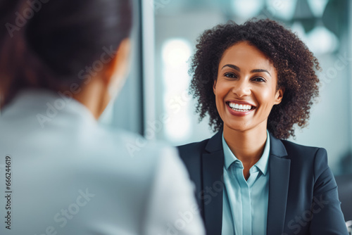 Happy middle aged black woman manager shaking hands with a business partner. Happy businesswoman making a deal with a partner, shaking hands.